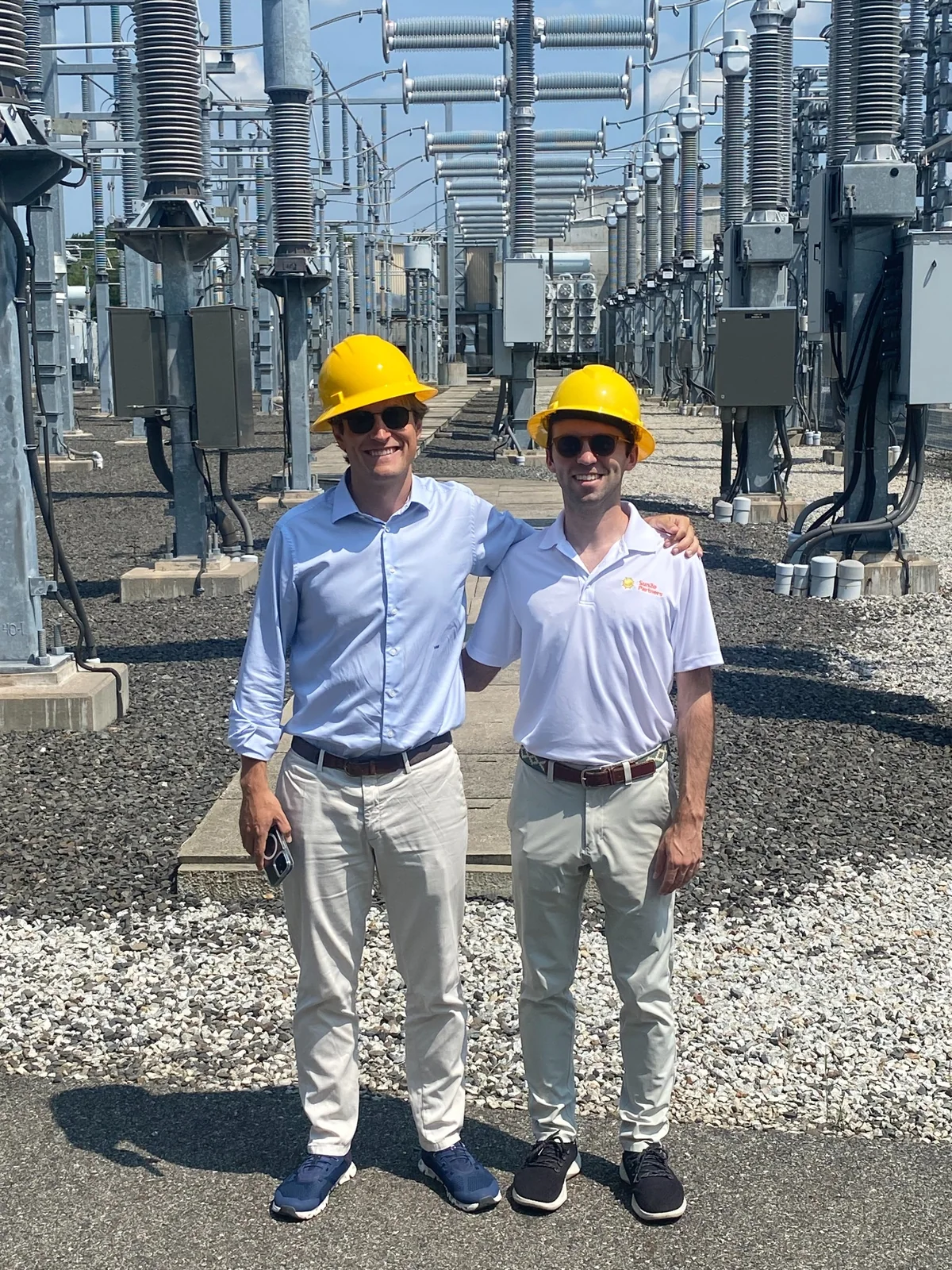 Victor Holten and Corey Kupersmith wearing hard hats during a substation visit